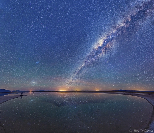 Magellanic Cloud galaxies and the Milky Way seen above the Salar de Atacama salt flat and reflected in the Laguna Cejar in northern Chile -image mosaic panorama by Alex Tudorica 
