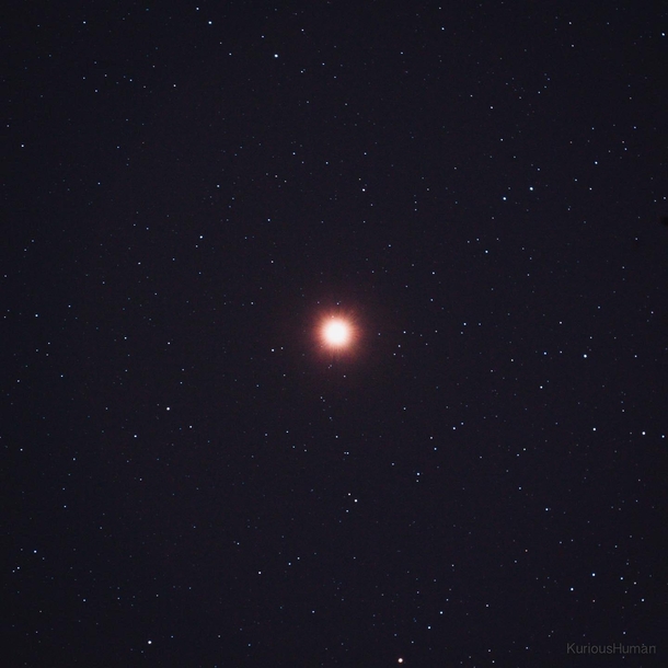 Mars shining bright in front of a field of stars