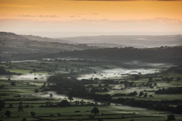 Mist lies in a valley near Goathland in the North Yorkshire Moors at sunrise 