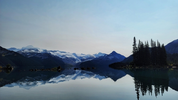 Morning with a sky full of smoke in serene Lake Garibaldi British Columbia Canada 