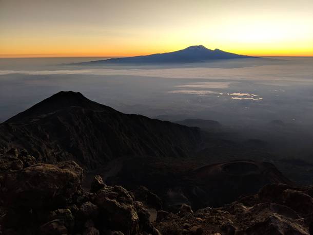 Mt Meru caldera with the sun rising behind Kilimanjaro in Tanzania 