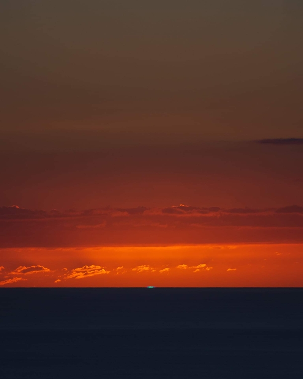 My grandpas friend captured this green flash in Kona Hawaii Its a phenomenon where theres a flash of green light when the sun setsrises over the ocean