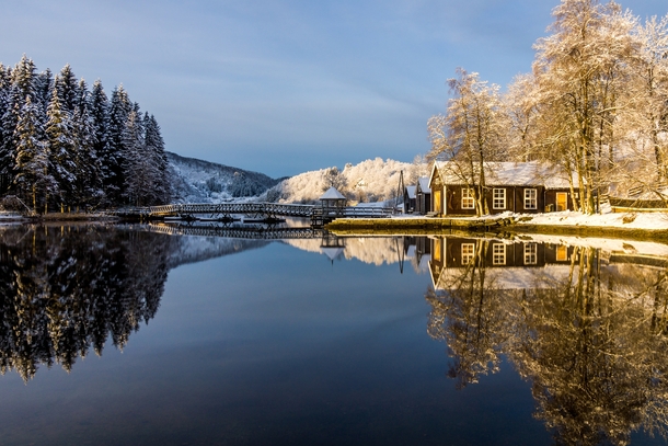 Norwegian cabins reflect in the water on a crisp day  Photographed by Richard Larssen