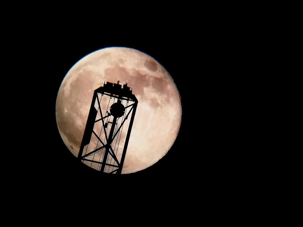 OC Almost full moon behind a crane from London