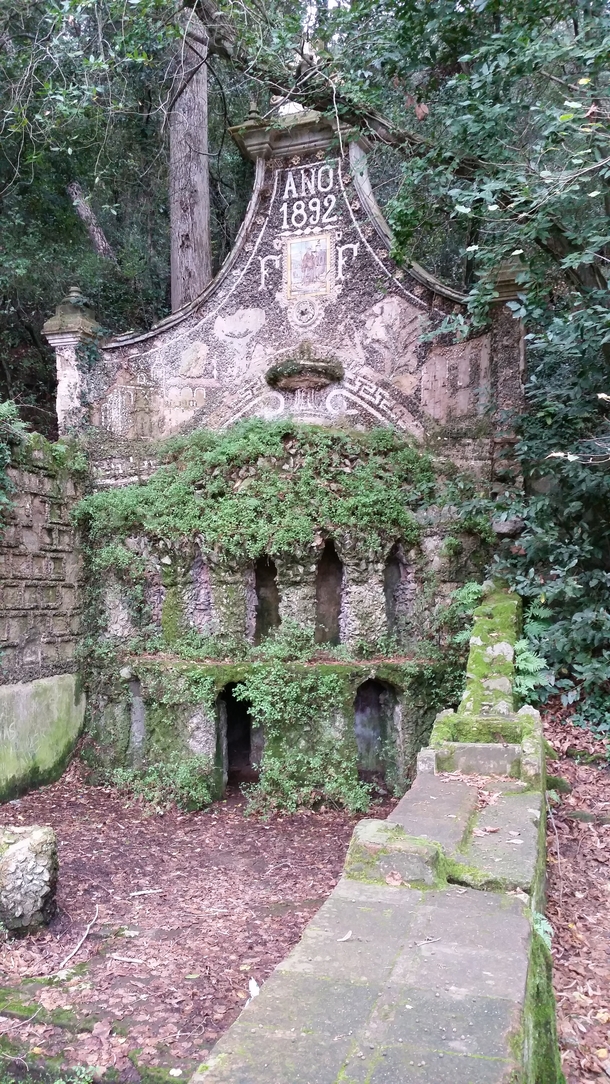 Old sanctuary-style now dry water fountain lost in the forest 