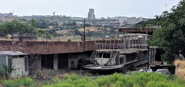 Once envisioned to ferry passengers across the manmade lake this craft in urban Yerevan now sits disused in front of a dilapidated boathouse