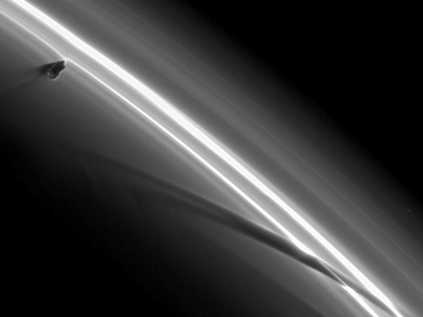 Prometheus one of Saturns many moons orbiting the F-ring and leaving a trail behind Taken by the Cassini spacecraft 