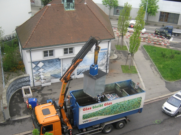 Recycling pick up in Switzerland Underground bins sit on scales and are emptied once they reach a certain weight The crane is operated by remote control by the driver and the bottom of each bin opens to empty into the truck Noisy but efficient