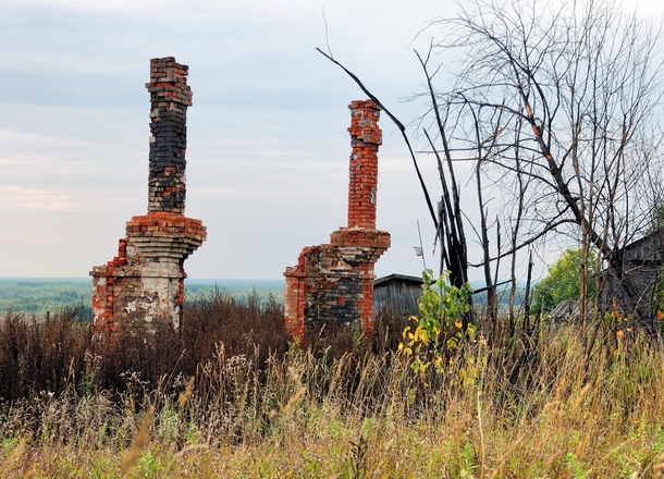 Remains of stoves and pipes on the site of a burned down two-apartment building in the abandoned village of Volosnitsa on the Kama River in Russia