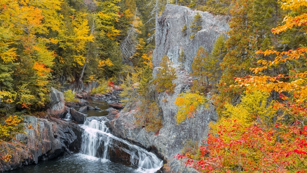 Rich fall foliage gracing the cliffs and waterfalls of Gulf Hagas Maine USA 