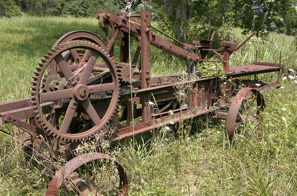 Rusting farm equipment in a field Western North Carolina 