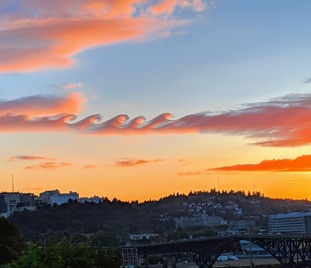 Science says these are Kelvin-Helmholtz clouds but it looks to be like an epic battle between ocean and fire 
