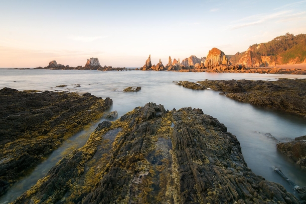 Sharp rock formations emerge during low tide in Gueira Asturias Spain 