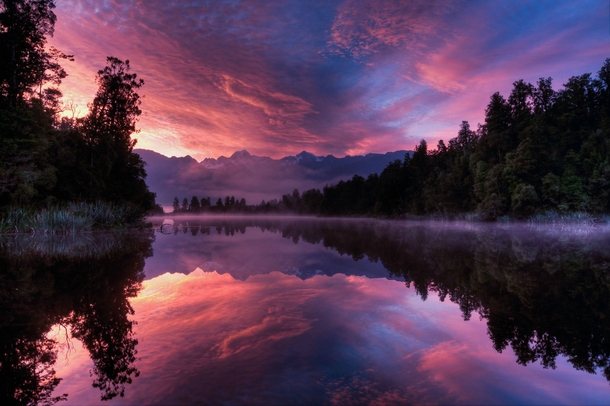 Someone mentioned we need more New Zealand photos so heres one I took at Lake Matheson near Fox Glacier at sunrise 