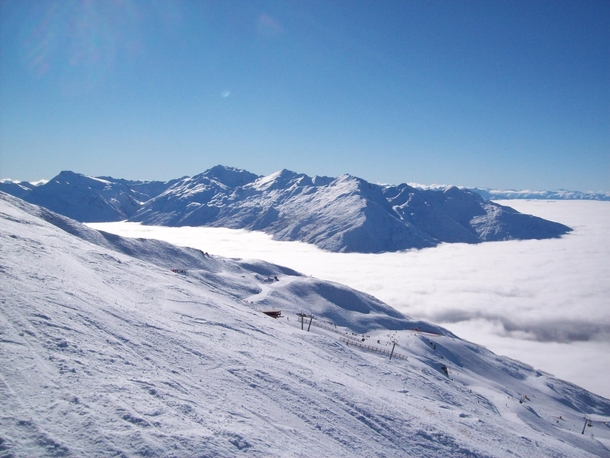 Southern Alps NZ poking up above the clouds  Photo taken from Treble Cone Skifield