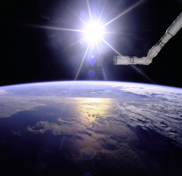 Space Shuttle Canadarm with a Sunburst pattern behind it 