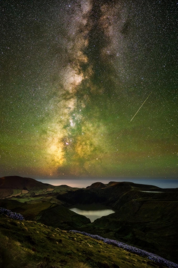 Starlit view over the southern highlands of the remote island of Flores in the middle of the Atlantic Ocean Ft Milky Way Airglow and a Perseid meteor pointing at Saturn Azores Portugal   mpxmark