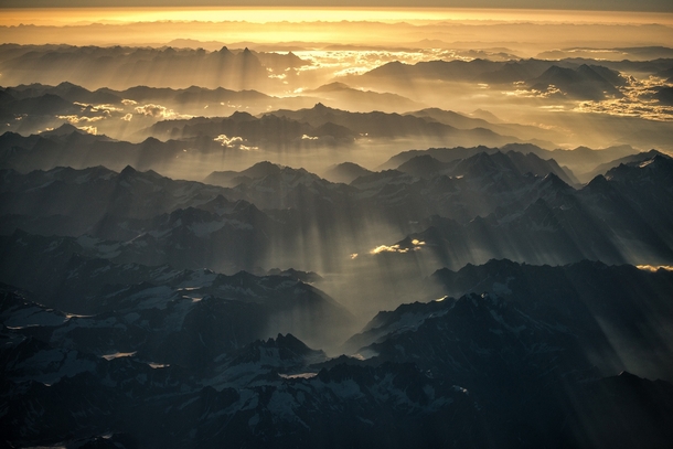 Streaks of sunlight shine over the Himalayas at dawn  by Nutthavood Punpeng