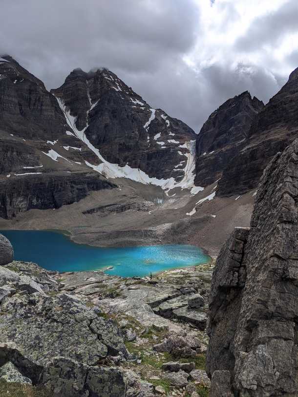 Sunlight briefly breaks through the clouds illuminating the turquoise colours of this alpine lake in the Canadian Rockies 