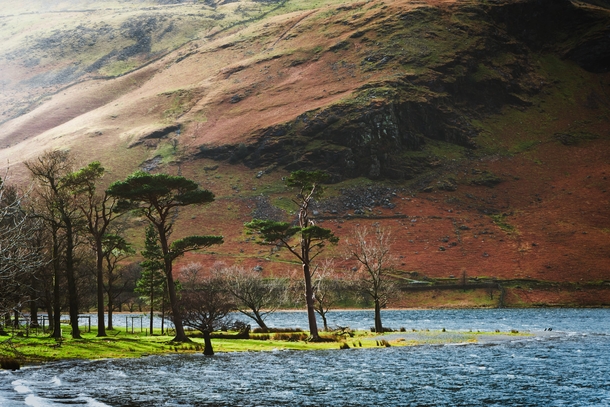 Sunlight catches the shoulder of High Crag and the shore of Buttermere below on a windy day Lake District England UK 