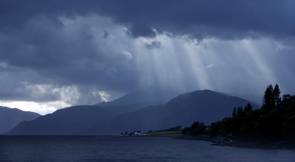 Suns rays breaking through a stormy sky nr Fort William Scotland