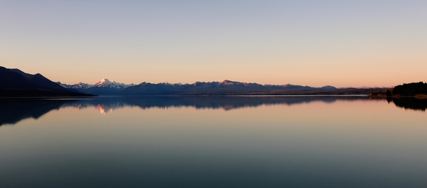 Sunset glow over calm lake and sky at Mount Cook Lake Pukaki New Zealand 