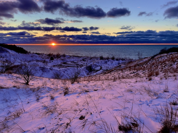 Sunset over snow-covered sand dunes Berrien County SW Michigan  