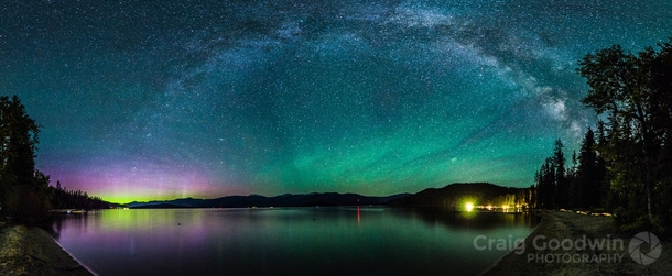 The Aurora Borealis dances in the lower left corner green waves of Airglow hover to the right and the Milky Way arch rises over it all Priest Lake Idaho United States 