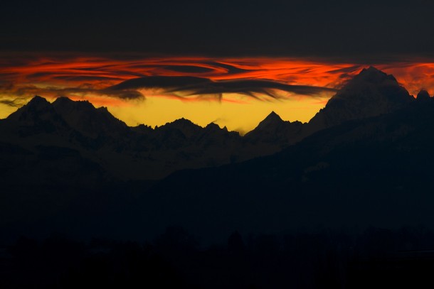 The French Alps seen from Geneva Switzerland under heavy clouds at sunrise 