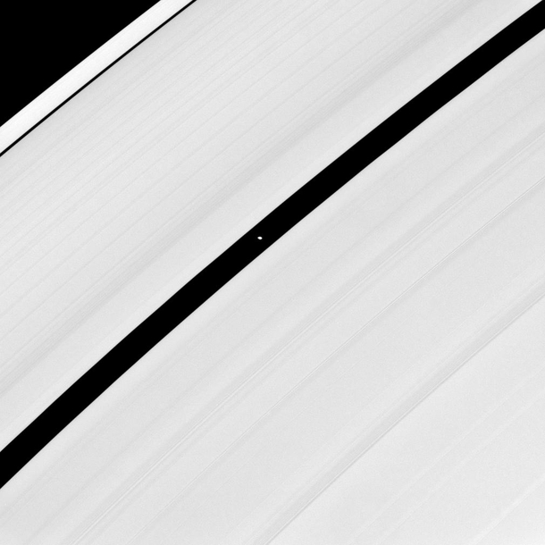 The higher resolution view of saucer-shaped Pan Saturns moon glides through the Encke Gap in Saturns rings