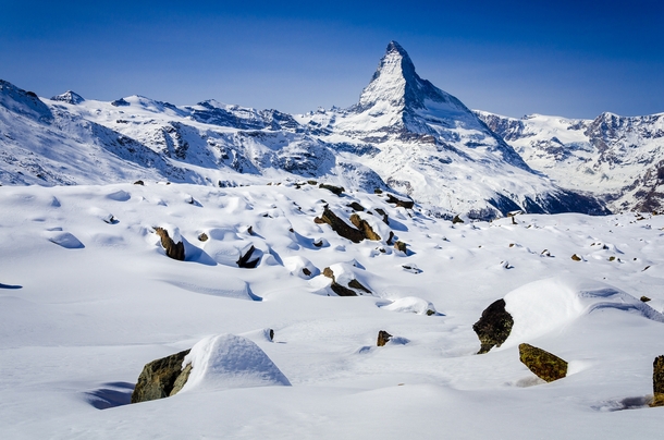 The Matterhorn standing tall over a snowy field of boulders - above Zermatt Switzerland 