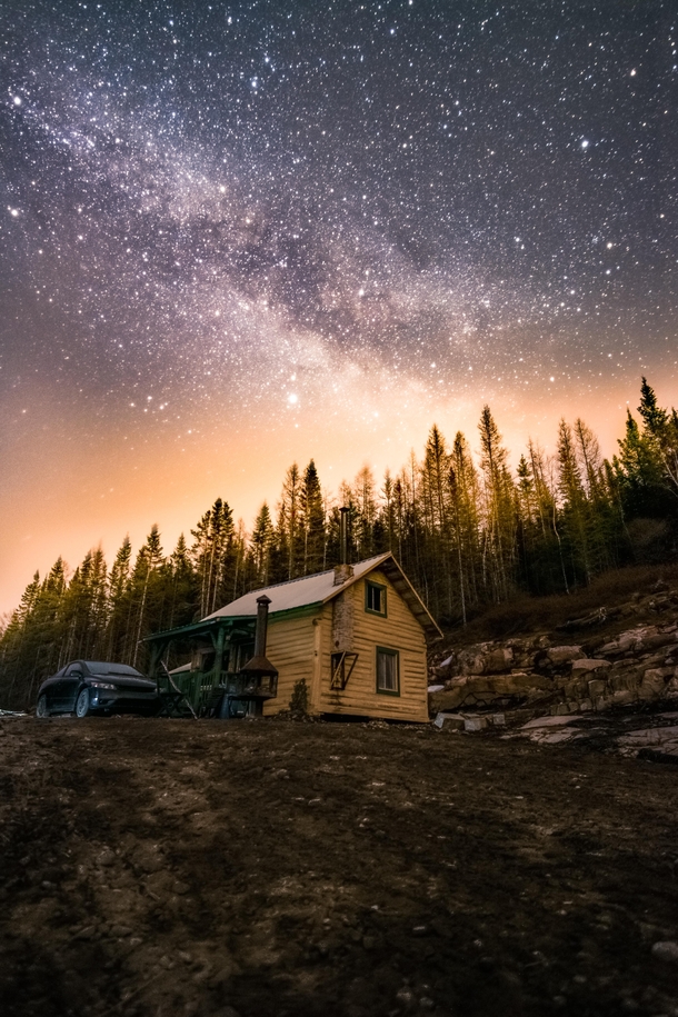 The Milky Way over a log cabin