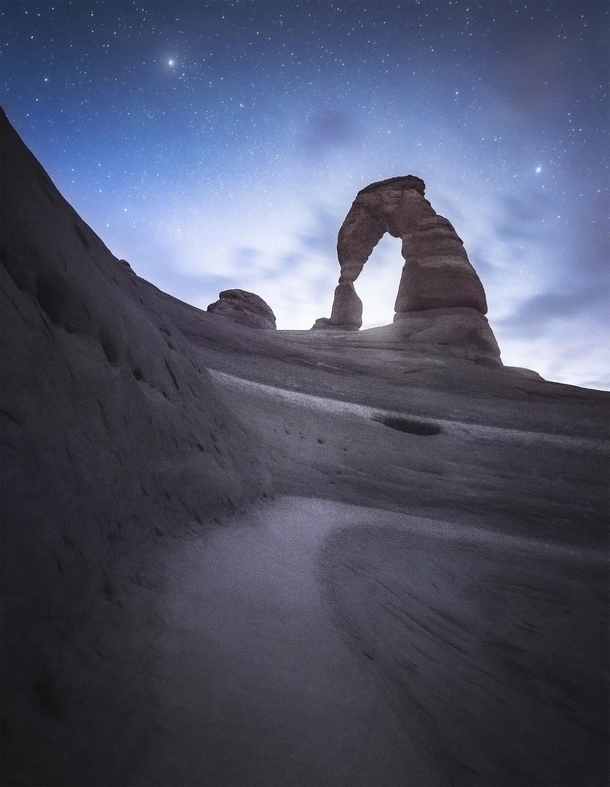The moon rises behind Delicate Arch 