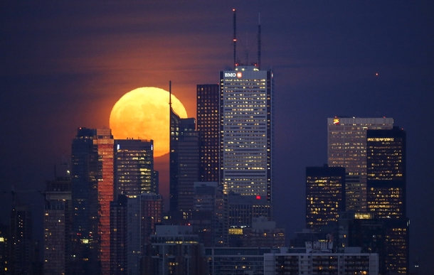 The moon rises behind the skyline and financial district in Toronto on November   Mark Blinch 