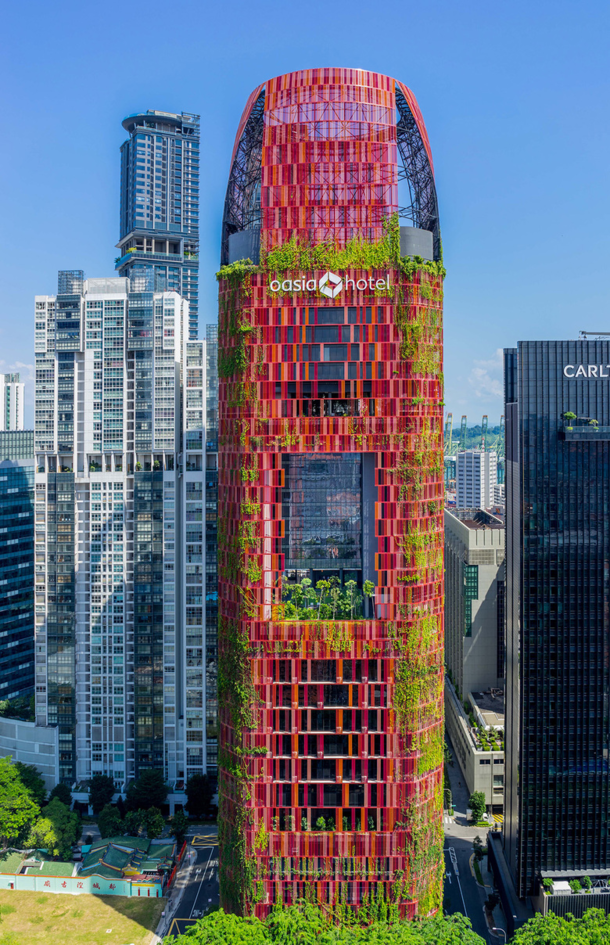 The Oasia Hotel Downtown designed by Woha a Singapore-based architectural firm is one of the most stunning skyscrapers in Asia Red aluminum mesh envelopes the building and intermingles with green plants and brightly colored flowers that provide shelter fo