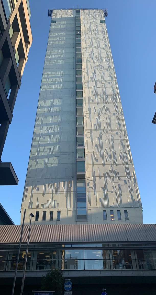 The sun shining on City Tower Manchester UK showing its circuit board inspired rear facade Manchester is noted as being the birthplace of the modern computer