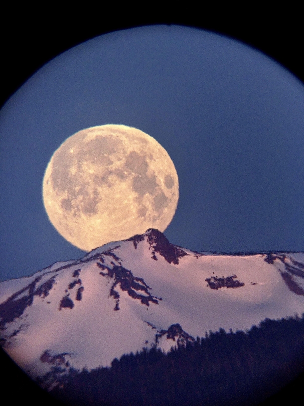 The Super Moon in May setting between South and Middle Sister taken with my iPhone through a telescope