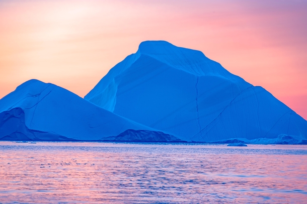 These are actually two icebergs that transformed into a brilliant blue shade as the light changed that evening in Ilulissat Greenland 