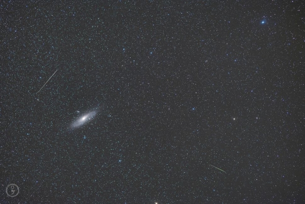 Two meteors whizz by the Andromeda galaxy in a deep space photograph by Omid Qadradan