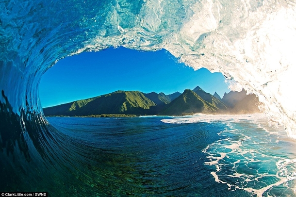 View of Tahiti from inside a wave during a morning surfing session 