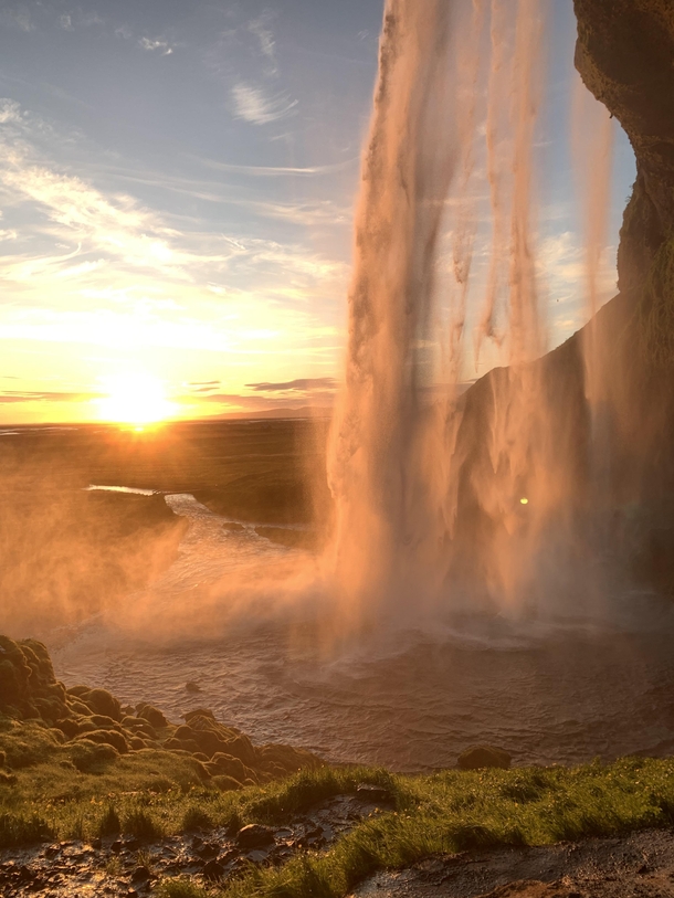 Watching the sunset from behind a waterfall in Iceland 