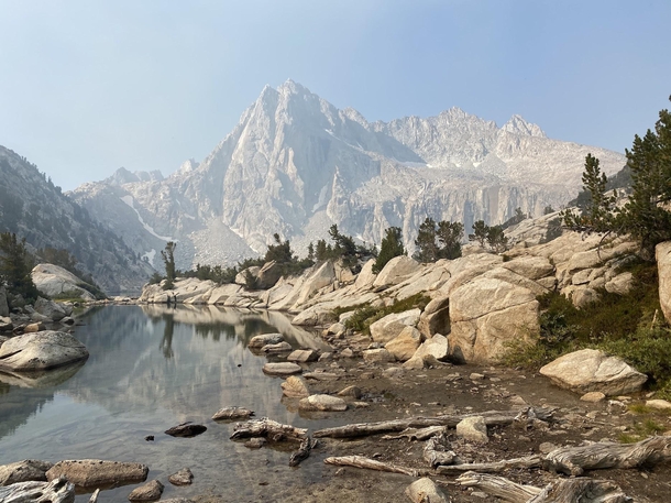 Wildflire smoke obscures the blue skies at the base of a prominent peak in California 
