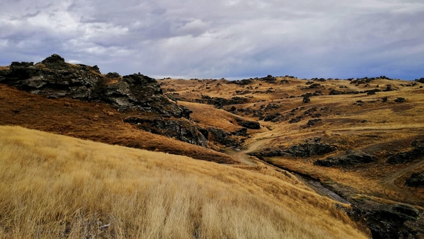 Yellow hills and black rock formations - Poolburn Lake New Zealand 
