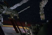  May  - A portion of the ISS is visible in this view of a starry sky and Earths horizon 