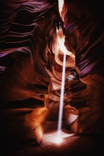 A beam of light drops into the Upper Antelope Canyon in the Navajo Nation  photo by Geoffrey Gilson