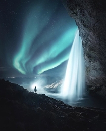 A beautiful wintry shot from Iceland The waterfall definitely accentuates the Aurora