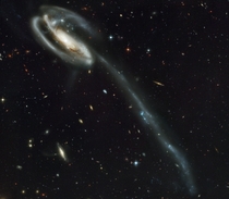 A cosmic hit and run UGC  has been distorted by the interloping galaxy emerging from the upper left spiral arm likely having done its damage and moving on Behind the galactic carnage about  faint galaxies Around twice the number of those found in the Hubb
