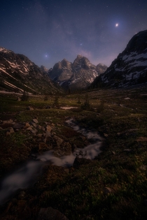 A faint milky way above the Grand Teton backcountry on a moonlit summer night 