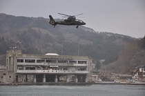 A Kawasaki OH- Ninja scout helicopter flies over the ruins of Funakoshi Bay in the wake of the tsunami th April  