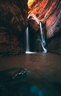 A lodged stone creates two streams in this waterfall outside of Moab Utah 